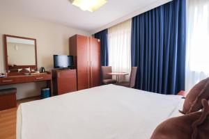 une chambre d'hôtel avec un lit et un miroir dans l'établissement Siyav Otel, à Ankara