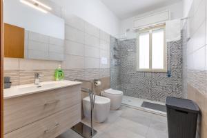 a bathroom with a toilet and a sink and a shower at Villa Primavera in Marina di Modica +18 photos