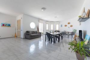 a living room with a table and chairs at Villa Primavera in Marina di Modica