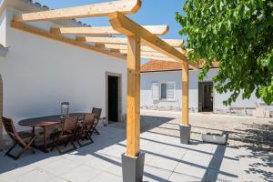 une pergola en bois avec une table et des chaises sur une terrasse dans l'établissement Riserva-La marea, à Vasto