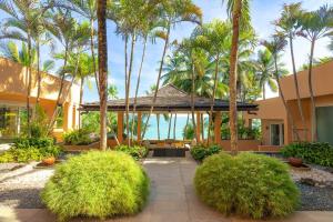 a courtyard with palm trees and a building at Coral Cove Beachfront Villa - Koh Chang in Ko Chang