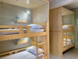 a bunk bed room with three bunk beds at The Moment Hostel Dulan in Donghe