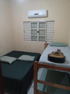 una camera con due letti e un cappello su un tavolo di Iporã casa simples Ar-cond, wi-fi, smartv, máquina de lavar 6 pessoas, equipado com churrasqueira, garagem para 4 carros sendo 2 coberta, Hop Independente ad Araçatuba