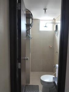 a bathroom with a toilet and a shower with a window at Condo staycation in SLP Bangkal Makati in Manila