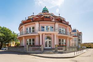 a pink building with a dome on top of it at Bałtyk Residence Międzyzdroje, BASEN, SAUNA Apartamenty 2,3,4 os z jacuzzi in Międzyzdroje