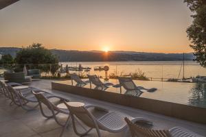 a group of chairs on a patio with a view of the water at Amadria Park Grand Hotel 4 Opatijska Cvijeta in Opatija