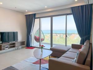 a living room with a couch and a large window at căn hộ the sóng 3 phòng ngủ in Vung Tau
