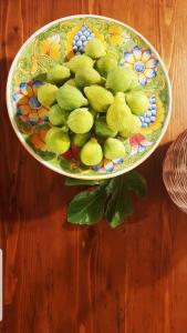 a plate of green fruit on a wooden table at Il Poggio al Sole in Fiesole