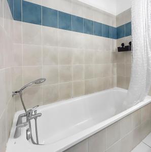 a white bath tub with a shower curtain in a bathroom at Appartement Aux Portes de Toulouse in Plaisance-du-Touch +20 photos