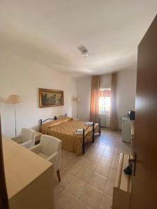 a hotel room with a bed and a living room at L'Ostello in Vasto +9 photos