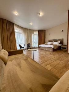 a large bedroom with a bed and a couch at MARCO Hotel in Goris