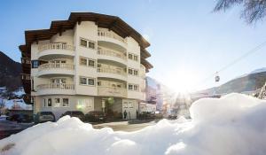 Un palazzo alto con la neve davanti di Hotel Valentin a Sölden