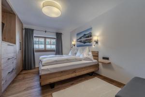 Un dormitorio con una cama grande con sábanas blancas. en Waltenberghof, en Kitzbühel 41 fotos más