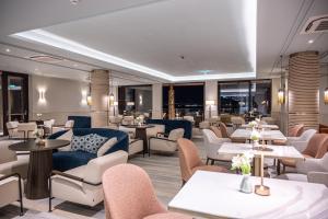 a restaurant with couches and tables and chairs at Amadria Park Grand Hotel 4 Opatijska Cvijeta in Opatija