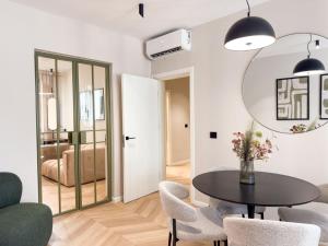 a dining room with a table and chairs and a mirror at Historic Business Loft in Iaşi