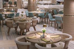a restaurant with tables and chairs in a room at Amadria Park Grand Hotel 4 Opatijska Cvijeta in Opatija