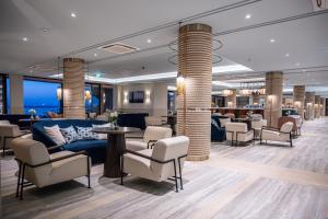 a waiting room with a blue couch and chairs at Amadria Park Grand Hotel 4 Opatijska Cvijeta in Opatija
