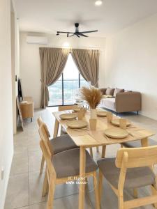 a dining room and living room with a table and chairs at Family Suites Netflix House Aston Acacia Bukit Mertajam in Bukit Mertajam