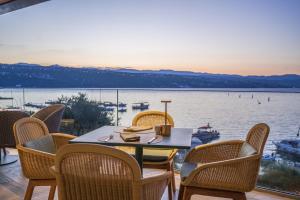 a table and chairs with a view of the water at Amadria Park Grand Hotel 4 Opatijska Cvijeta in Opatija