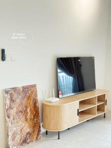 a flat screen tv sitting on top of a wooden entertainment center at Family Suites Netflix House Aston Acacia Bukit Mertajam in Bukit Mertajam