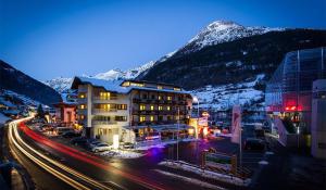 un edificio in una strada di fronte a una montagna di Hotel Valentin a Sölden