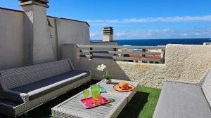 a patio with a table and chairs and the ocean at Vista Mare Baia Santa Reparata in Santa Reparata