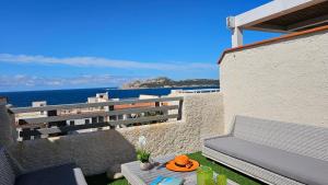 a balcony with a bench and a view of the ocean at Vista Mare Baia Santa Reparata in Santa Reparata