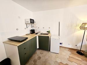 a small kitchen with a sink and a microwave at Maison de ville calme au cœur de Chartres Netflix, salle de sport, garage vélo in Chartres +11 photos