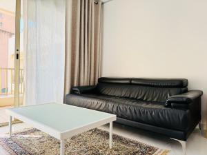 a living room with a black leather couch and a white table at Princess Palace Monte-Carlo in Monte Carlo