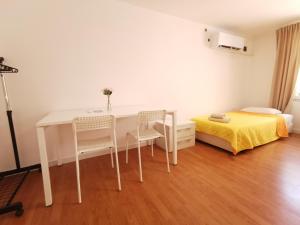a room with a table and chairs and a bed at Studio Garden City Center Pomorie in Pomorie
