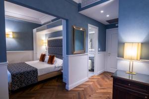 a bedroom with blue walls and a bed with a mirror at Rivoli Boutique Hotel in Florence