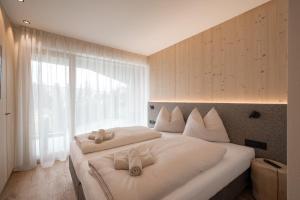 ein Schlafzimmer mit zwei Betten mit weißen Kissen und einem Fenster in der Unterkunft Walderhof Natz in Natz-Schabs + 70 Fotos