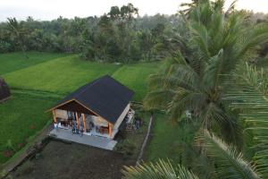 an overhead view of a small house with a black roof at Green House Tetebatu in Tetebatu