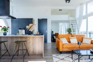 a living room and kitchen with a couch and a table at Penthouse aan het strand - met balkon | Nr. 26 - 2 Pers | Vista Maris in Sint Annaland
