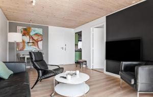 a living room with a couch and a tv at Holiday Home Lingbanke in Skagen