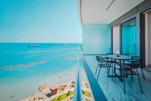 a balcony with a table and chairs and the beach at Stunning 1 Bed in Trilogy, Limassol Seafront in Limassol
