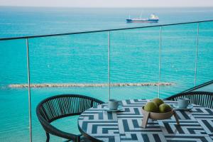 a table with a bowl of fruit on top of the ocean at Stunning 1 Bed in Trilogy, Limassol Seafront in Limassol