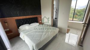 a bedroom with a bed with a black headboard at Green Guest House Malang in Kasri