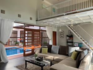 a living room with a couch and a swimming pool at Casa Tanjung Jara Villa in Kampong Gok Kapor