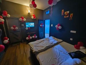 a bedroom with balloons on the wall and a bed at Rudra Paying Guest House in Varanasi