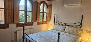 a bedroom with a bed in a room with windows at Apartamentos Casa Yaya al lado de Port Aventura in Vila-seca +67 photos