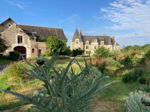 an old house with a garden in front of it at Cottage du collectionneur in Saint-Laurent-du-Mottay