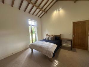 ein Schlafzimmer mit einem Bett und einem großen Fenster in der Unterkunft The Old stables Barn in Old Hurst