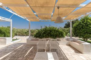 a patio with a white couch and a table at Il Gelsomino Bianco by BarbarHouse in Mottola