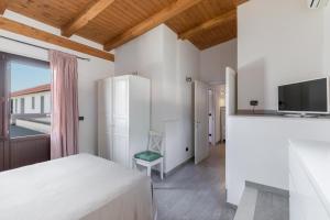 a bedroom with a bed and a tv and a window at Il Gelsomino Bianco by BarbarHouse in Mottola