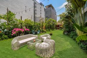 Un jardín con dos sillas de mimbre y una mesa. en Tashi Ocean Hotel & Apartment Da Nang - Free Gym Access, en Da Nang