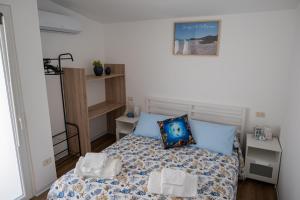 Cette petite chambre comprend un lit avec des oreillers bleus. dans l'établissement Riserva-La marea, à Vasto