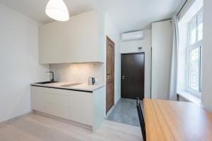 a kitchen with white cabinets and a wooden table at Studio apartment in Tartu in Tartu