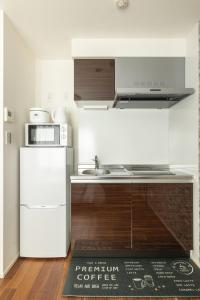 a kitchen with a white refrigerator and a kitchen rug at self-check in 67HOTEL AKIHABARA in Tokyo +92 photos