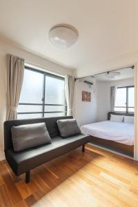 a bedroom with a bed and a couch at self-check in 67HOTEL AKIHABARA in Tokyo
